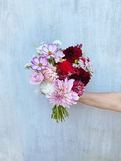 a person holding a bouquet of flowers in their hand