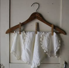 an old pair of shorts hanging from a wooden hanger on a white painted door