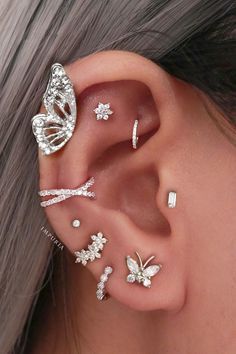 a woman's ear with three different types of piercings