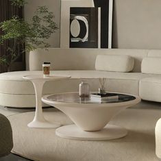 a living room with white couches and tables