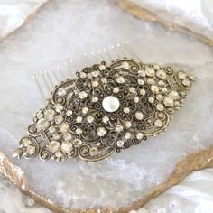 This amazingly detailed hair comb is created with antique brass filigrees that I encrusted by hand with Premium European golden shadow crystals.  I also placed a lovely ivory crystal pearl in the center.   Comb measures 4 inches across and 2 inches up and down (filigree only, almost 3 inches from bottom of comb to top of filigree)   A perfect addition to your wedding or special occassion. Also available in antique silver with clear crystals. https://www.etsy.com/listing/122534457/bridal-hair-com Luxury Antique Clip-on Earrings For Wedding, Victorian Clip-on Wedding Jewelry, Antique Clip-on Jewelry For Wedding, Antique Hair Clips, Antique Hair Comb, Art Deco Hair Combs, Vintage Bridal Hair, Rose Gold Bridal Earrings, Gold Hair Comb