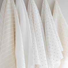 four white towels hanging on a wall next to each other with polka dot designs in them