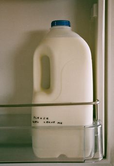 a gallon of milk sitting on top of a shelf