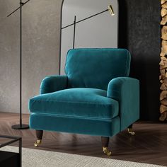 a blue chair sitting in front of a mirror on top of a wooden floor next to a lamp