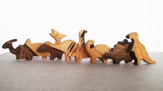 wooden toy dinosaurs lined up in a row