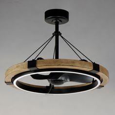 a circular light fixture with wood and metal rings hanging from it's center point