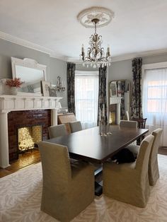 a dining room table and chairs in front of a fireplace