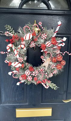 a wreath with candy canes and candies hanging on the side of a door