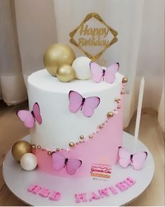 a birthday cake decorated with pink and gold butterflies