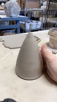 a person is making a vase out of clay