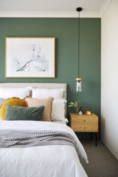 a bedroom with green walls and white bedding