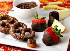 chocolate covered pretzels, strawberries, and apples are on a white plate