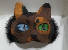 A Tortoiseshell cat mask colored brown, black, and orange with blue + green eyes. Has black fur on the sides of the face. the back and nose are painted black. the nose is kinda squishy. some of the photo's quality is bad but it will look better in person. Cat Therian Mask, Cat Therian, Tortoiseshell Cat, Therian Mask, Blue Green Eyes, Tortoise Shell Cat, Cat Mask, Black And Orange, Holiday Deals