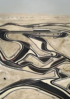 an aerial view of a winding road in the desert