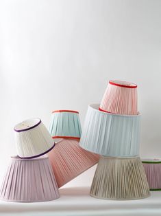 four different shades of pleated lampshades on a white background, one is pink and the other is blue