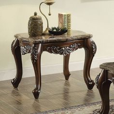 a table with a vase and some books on top of it next to a chair