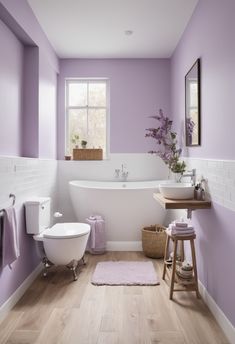 a white bath tub sitting next to a toilet under a window in a purple bathroom