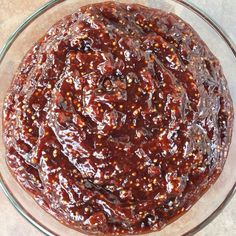 a glass bowl filled with sauce on top of a table