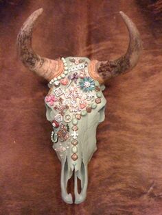 a cow's skull is adorned with jewels and beads