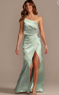 a woman in a long green dress with one leg slited up and the other side split