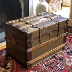 two trunks stacked on top of each other in front of a fire place and rug