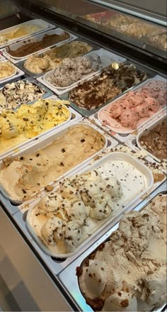 an ice cream display case filled with lots of different types of ice cream and toppings