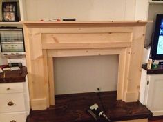 a living room with a fire place and television on top of the fireplace mantel