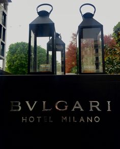 two black lanterns sitting on top of a hotel sign with the words bvlgarti