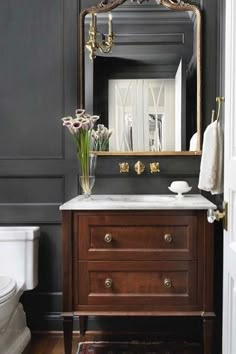 a bathroom with a sink, mirror and toilet in it's centerpieces