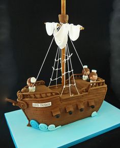 a cake made to look like a boat with people on it's deck and sails