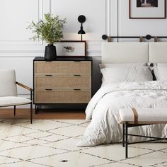 a bed with white sheets and pillows next to a dresser, chair and lamp in a bedroom