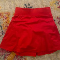 a red skirt laying on top of a rug