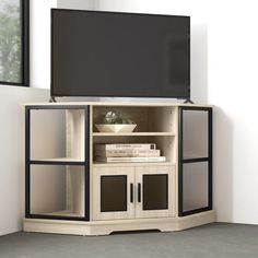 an entertainment center with a flat screen tv mounted on it's side, in front of a window