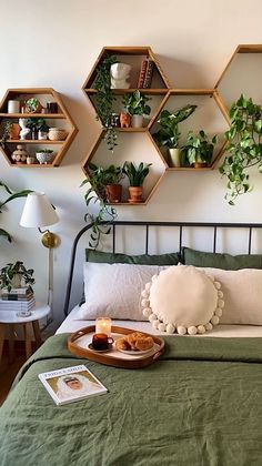 a bed topped with lots of plants next to a wall mounted shelf