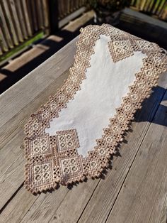 an old doily is laying on a wooden table