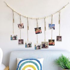 a bed with pictures hanging on the wall and a potted plant next to it