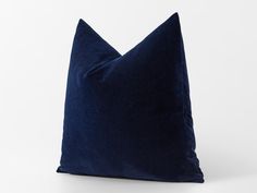 a blue velvet pillow on a white background