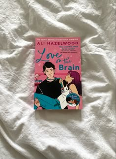 the book love on the brain by ali hazlewood is laying on a bed