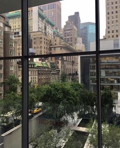 the view from inside an office building looking out onto a park and cityscape