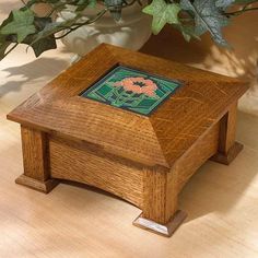 a small wooden box sitting on top of a table next to a potted plant