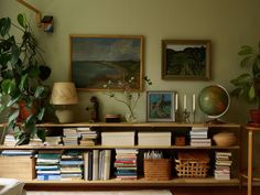 a living room filled with lots of books and plants