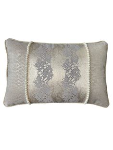 a gray and white decorative pillow with sequins on the edges, in front of a