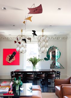 a living room filled with furniture and a chandelier hanging from the ceiling over a table