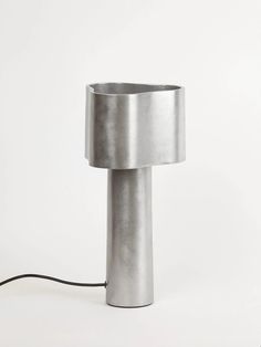 a lamp that is on top of a white surface with a cord attached to it