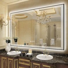 a bathroom with two sinks and a large mirror over it's counter top area