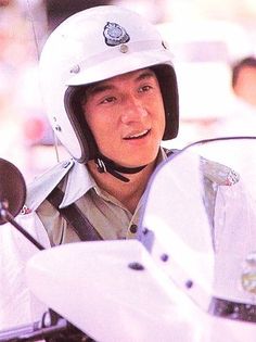 a man wearing a white helmet sitting on a motorcycle