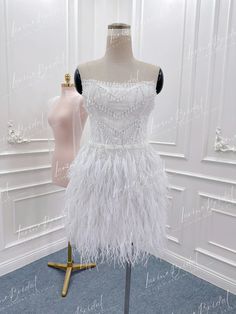 a white dress on display in front of a mannequin with beads and sequins