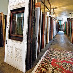 a long hallway with lots of doors and rugs on the floor next to each other