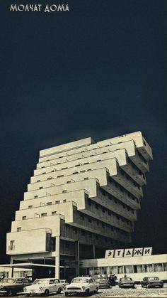 an old photo of a building with cars parked in front of it and the words mogani aoma written on the side