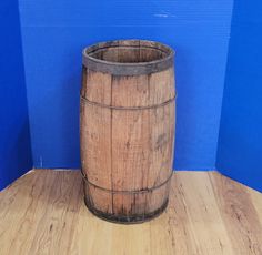 a wooden barrel sitting on top of a hard wood floor next to a blue wall